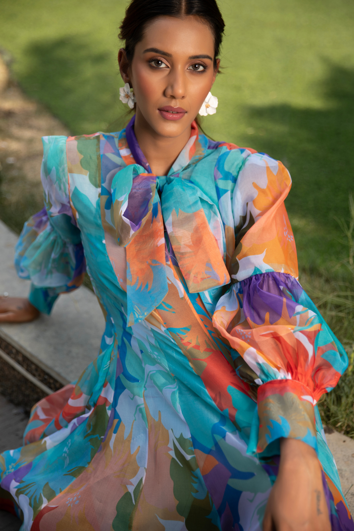 A flowy aqua- toned printed dress with an elegant bow detail offering a fresh and feminine look Shop Now!