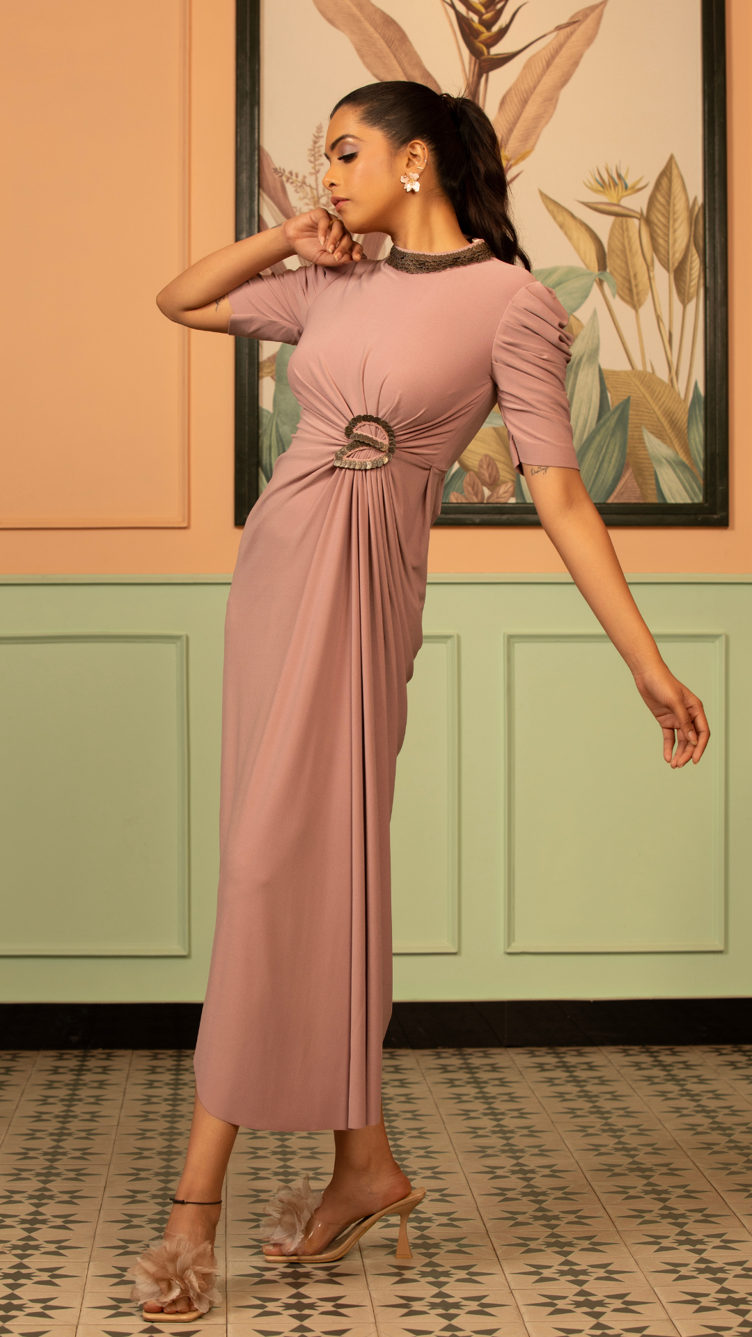 The blush coin drape dress fitted bodices with distinctive drape wrape style front that gather at the waist puff sleeve a classic high round neckline hand work elements like pearl beads Shop Now!