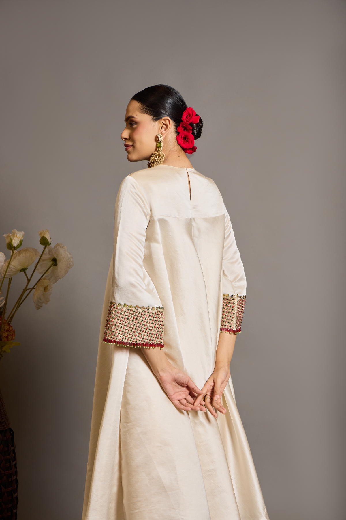 An elegant ivory kurta set crafted in a lustrous fabric, paired with tapered trousers and a fluid dupatta. Features exquisite multicolour handcrafted embroidery with ornate paisley-inspired motifs. A delicately embellished dupatta with gold edging and richly embroidered cuffs completes the look . Shop Now!