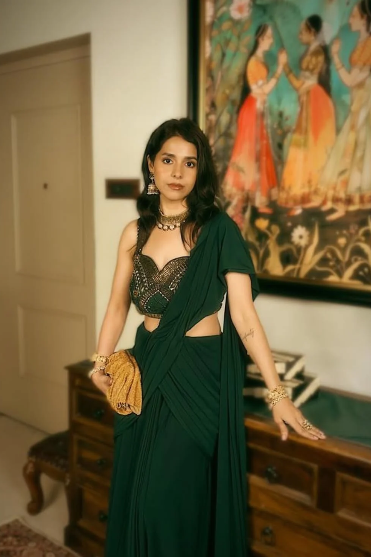 Emerald green pre-draped lycra saree with metallic rivet, sequin, bead, and cutdana work, paired with a corset blouse. Shop Now!