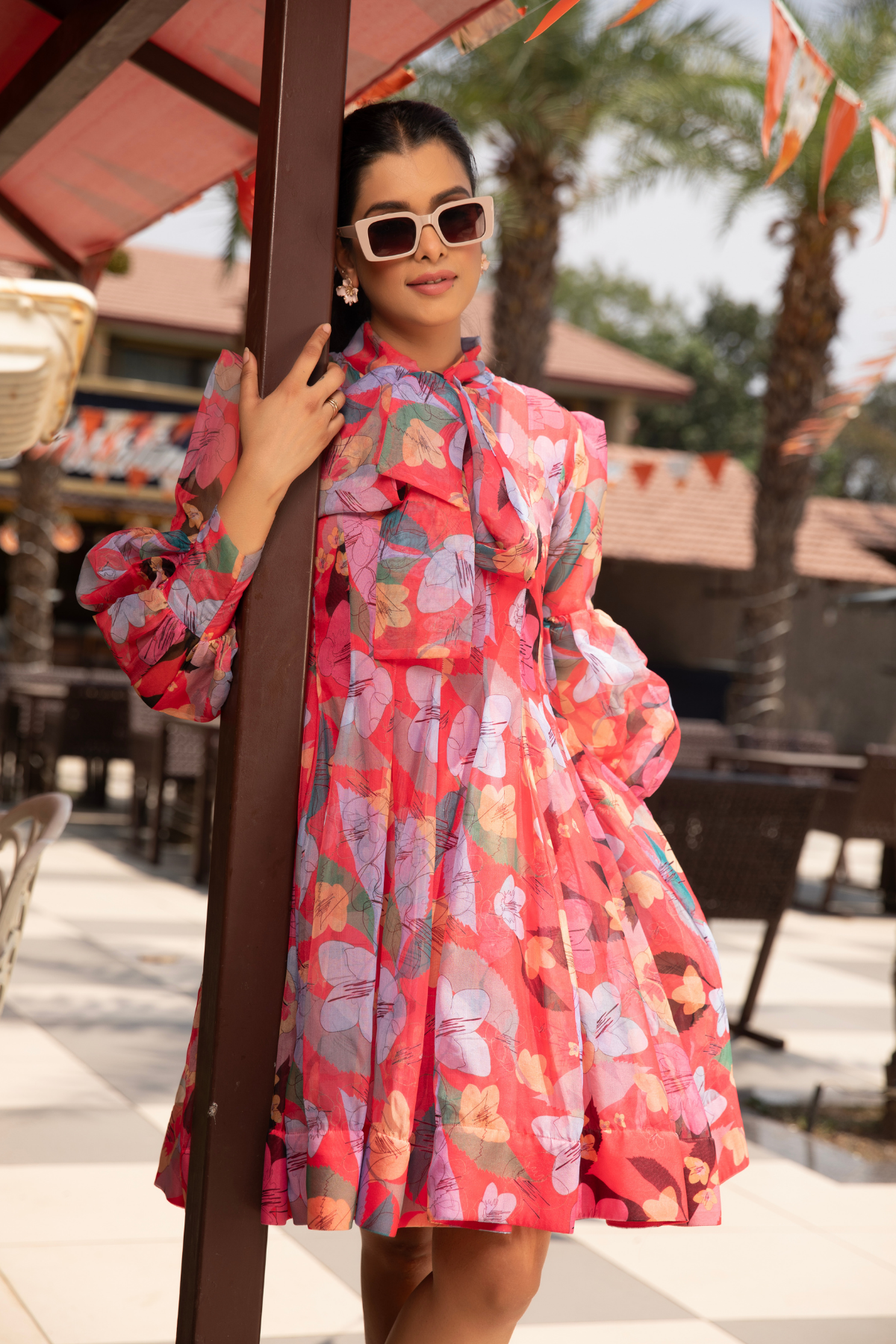 A floral inspired dress with vibrant hibiscus colour and a bow accent Shop Now!