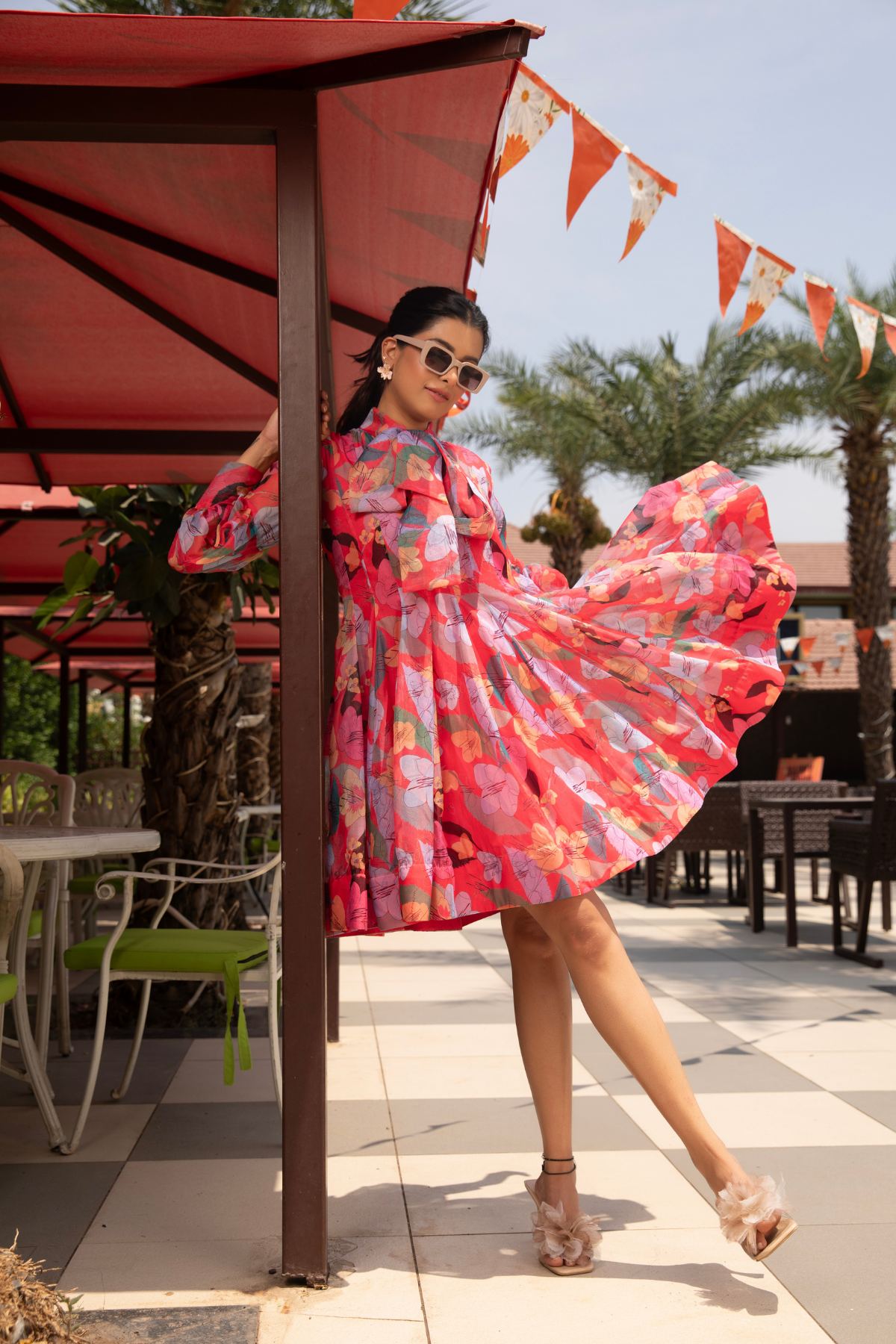 A floral inspired dress with vibrant hibiscus colour and a bow accent Shop Now!