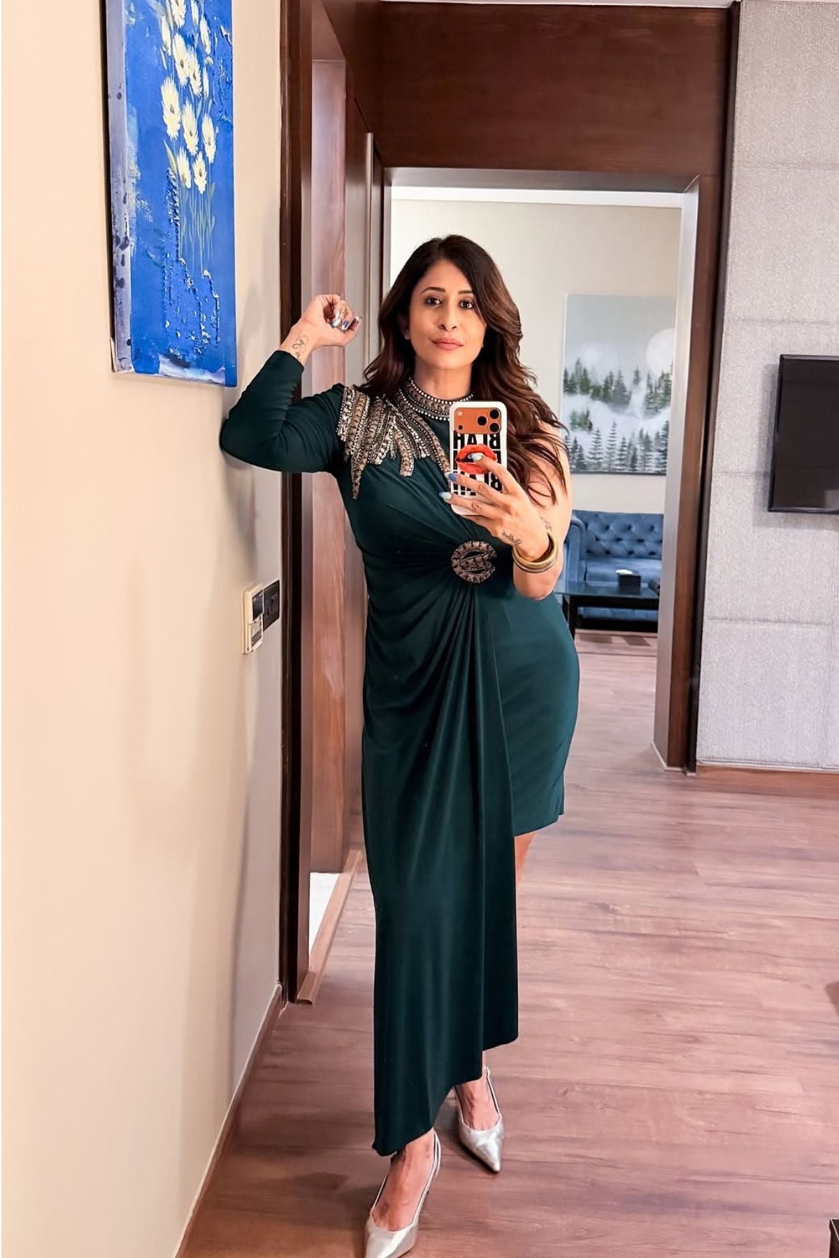 Asymmetric gown deep emerald green hue blending morder tailoring with intricate traditional embellishment fitted waist and a fluid draped faux wrap skirt at the midsection. Shop Now!