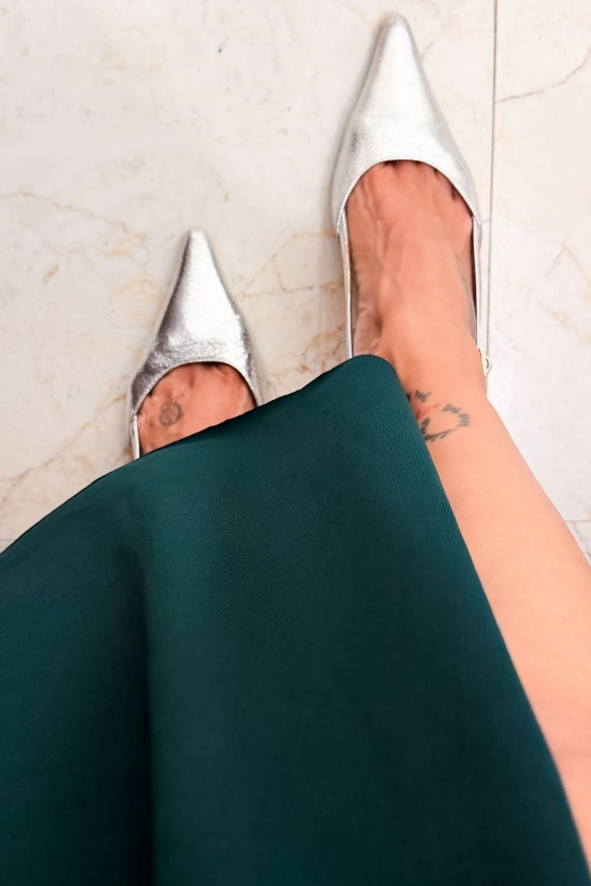 Asymmetric gown deep emerald green hue blending morder tailoring with intricate traditional embellishment fitted waist and a fluid draped faux wrap skirt at the midsection. Shop Now!