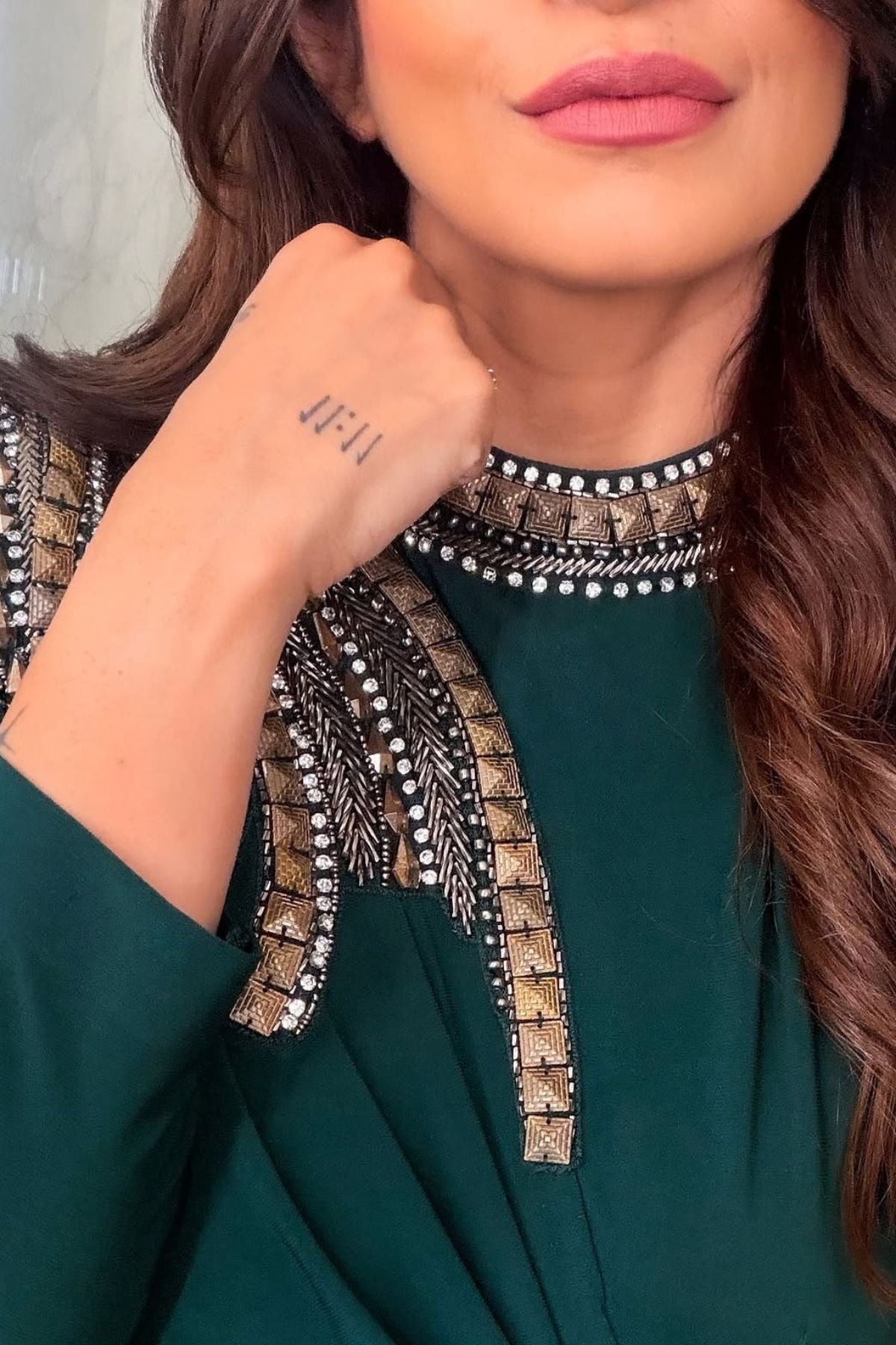 Asymmetric gown deep emerald green hue blending morder tailoring with intricate traditional embellishment fitted waist and a fluid draped faux wrap skirt at the midsection. Shop Now!