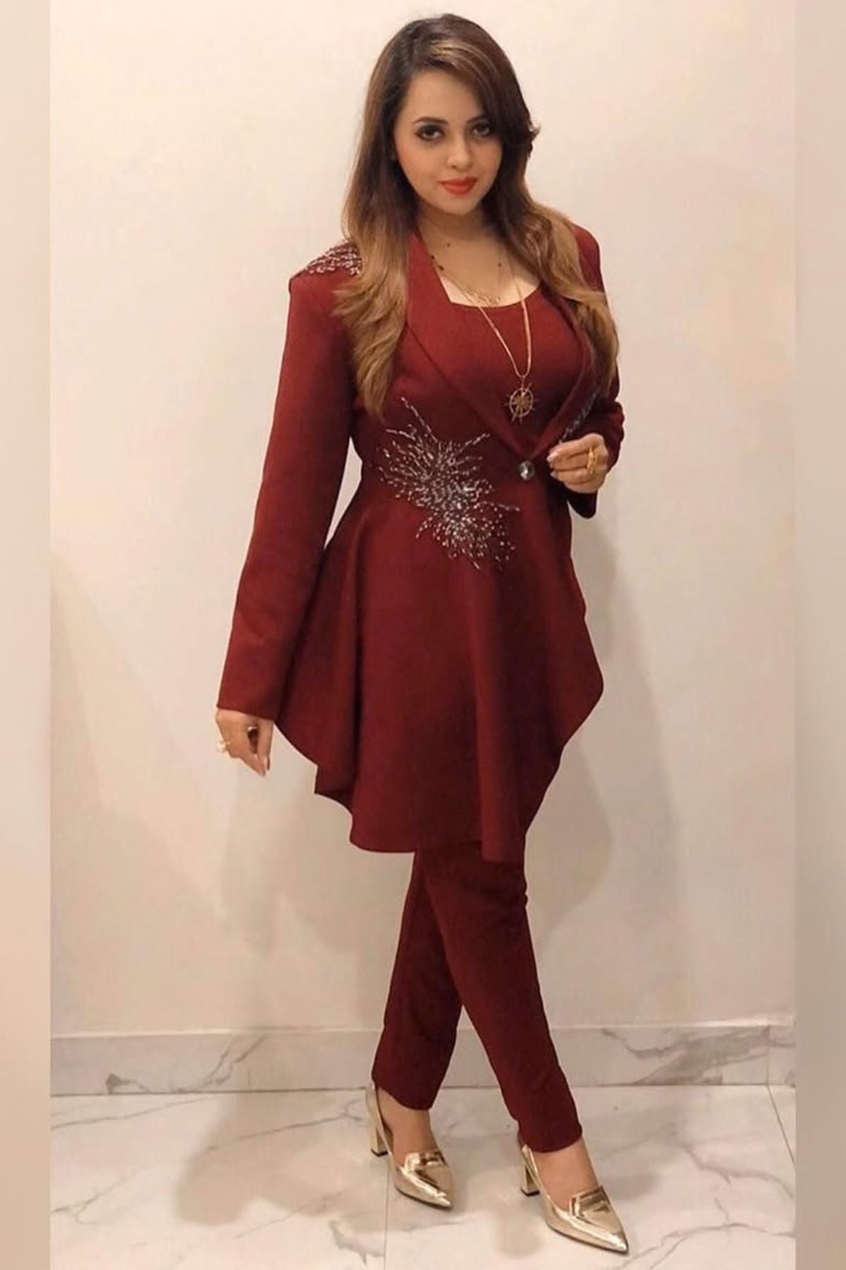 Tailored to sartorial perfection this single-breasted roll collar, peplum style blazer is paired with classic trousers. Its artistic intricate hand-embroidery with a mix of pipes, beads, sequin,cutdana, etc reflects aesthetic craftsmanship . Shop Now!