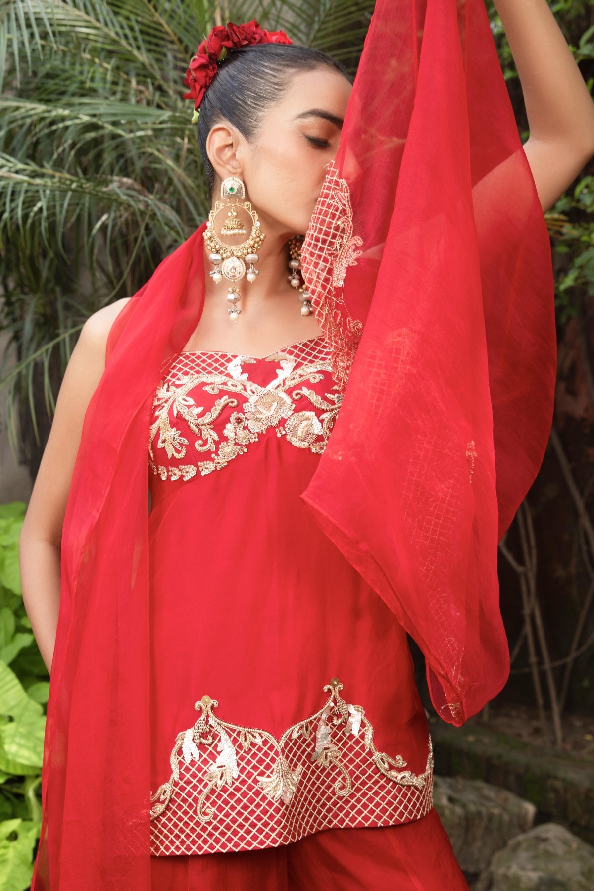 Scarlet red silk corset peplum top with Rococo-inspired hand embellishments, paired with organza palazzo and dupatta featuring zari. Shop Now!