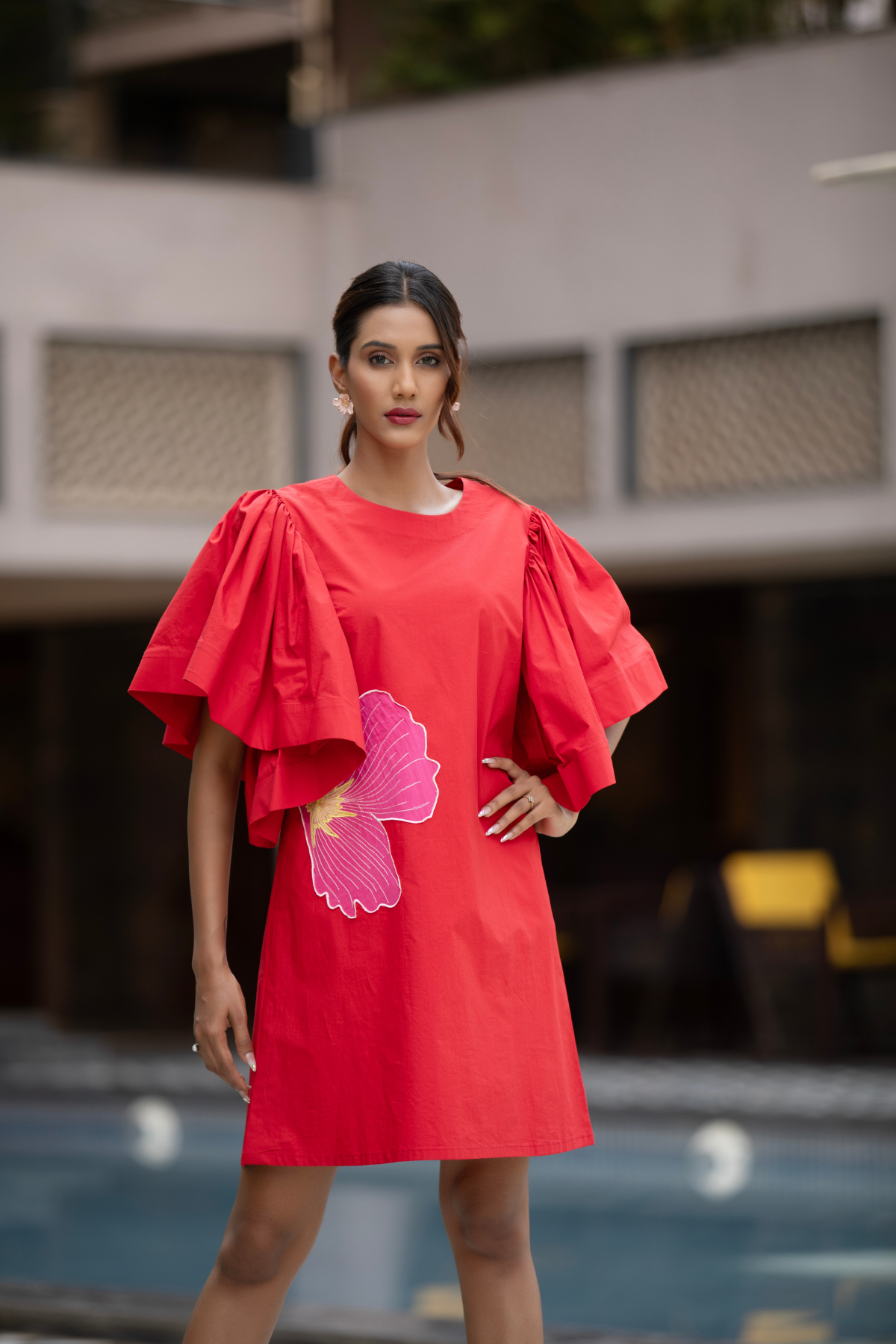 The dress is a vibrant red shift mini dress balance as relaxed fit and bold architectural details Shop Now!