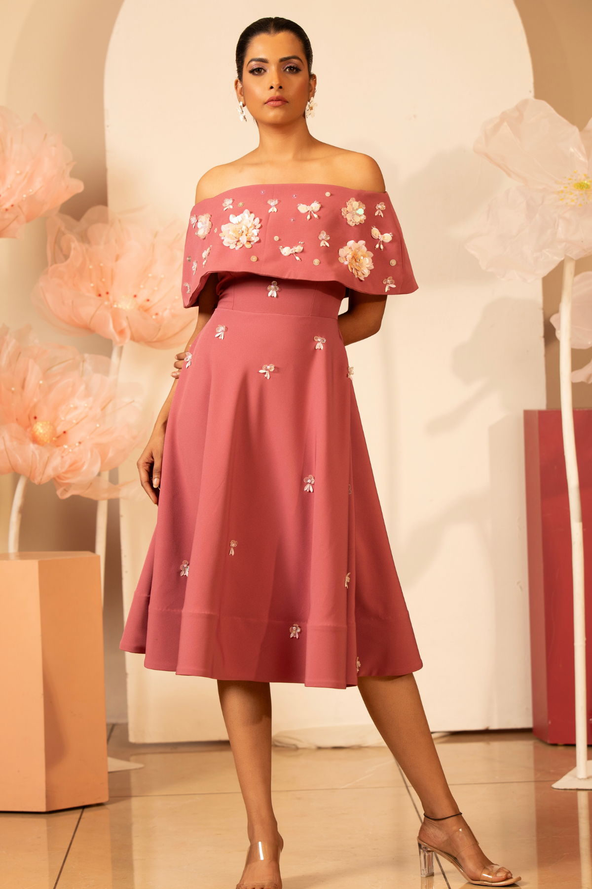 The off the shoulder dress which delicate three dimentional floral applique and flower motif with light handed detailing sequins and bead.Fit and flare falls to a mid calf length Shop Now!