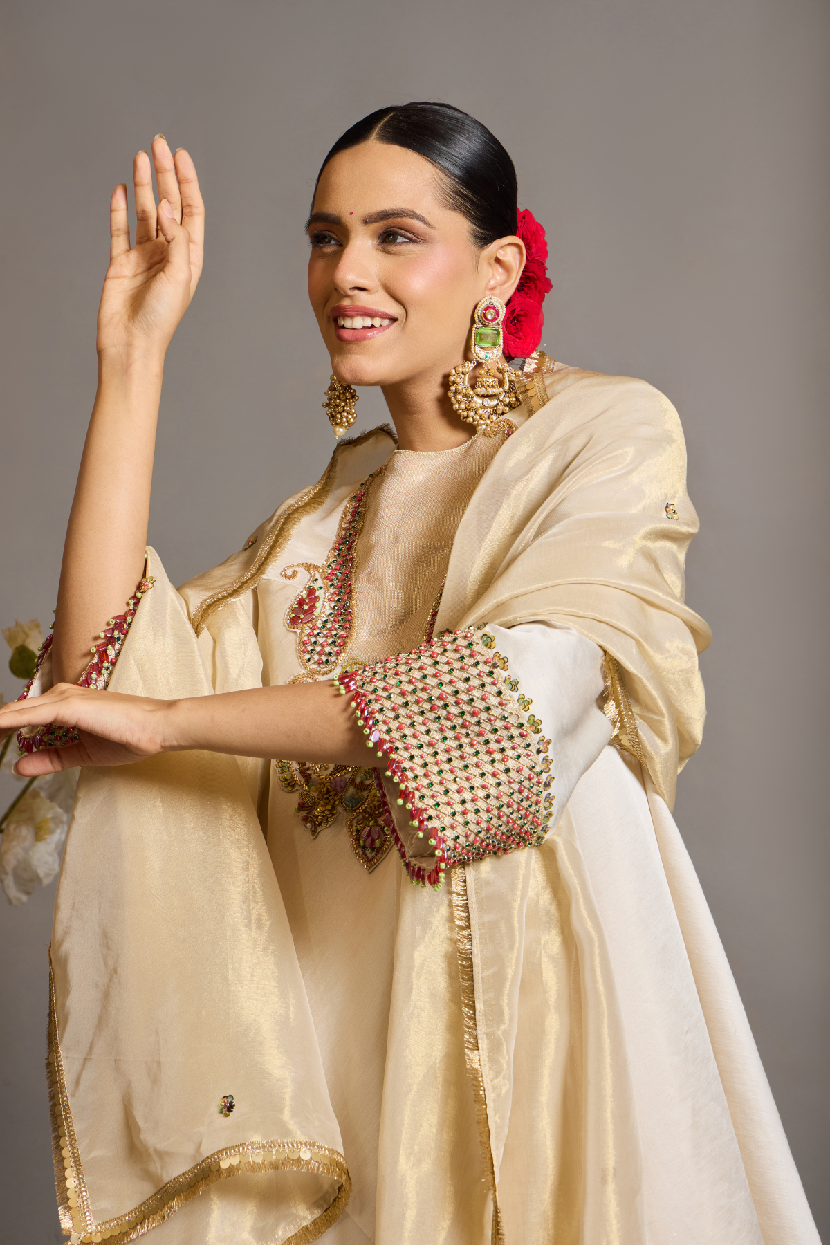 An elegant ivory kurta set crafted in a lustrous fabric, paired with tapered trousers and a fluid dupatta. Features exquisite multicolour handcrafted embroidery with ornate paisley-inspired motifs. A delicately embellished dupatta with gold edging and richly embroidered cuffs completes the look . Shop Now!