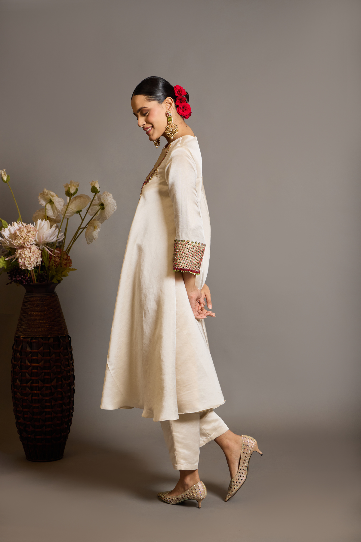 An elegant ivory kurta set crafted in a lustrous fabric, paired with tapered trousers and a fluid dupatta. Features exquisite multicolour handcrafted embroidery with ornate paisley-inspired motifs. A delicately embellished dupatta with gold edging and richly embroidered cuffs completes the look . Shop Now!