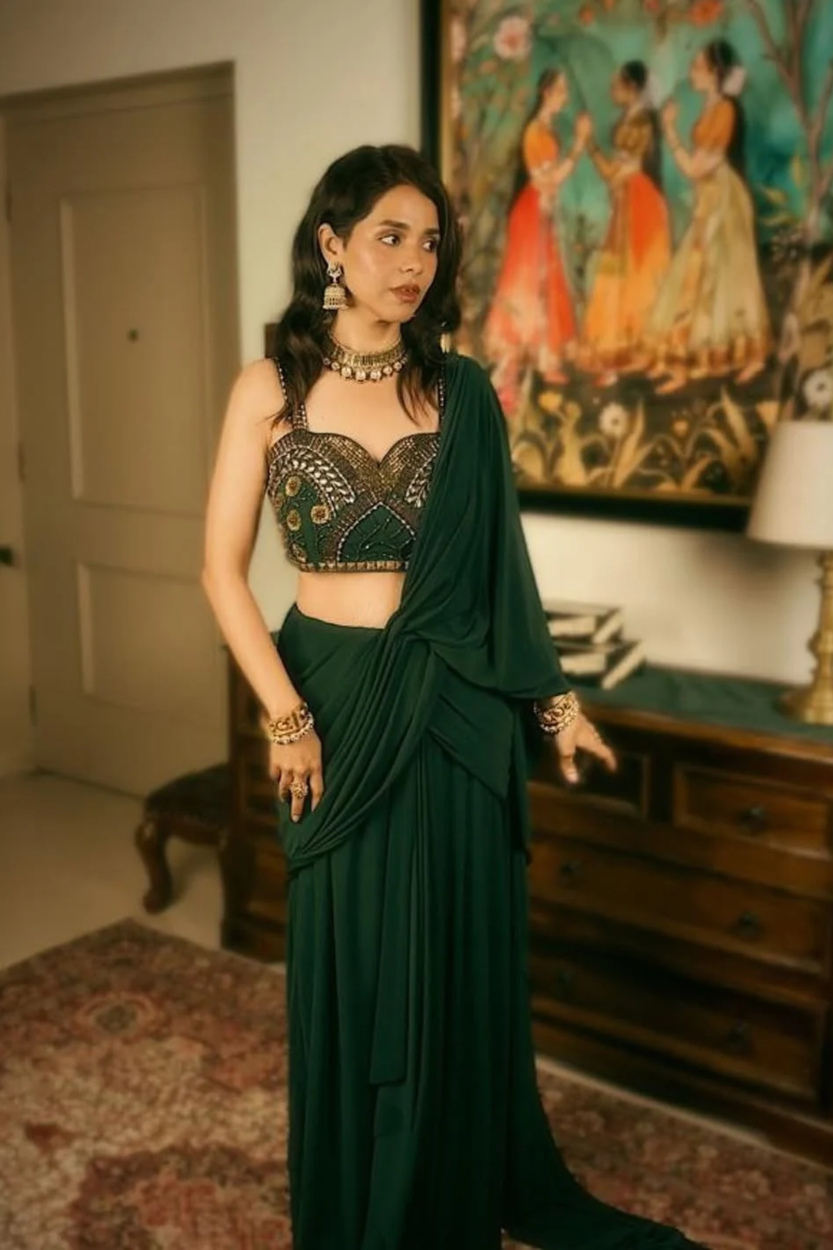 Emerald green pre-draped lycra saree with metallic rivet, sequin, bead, and cutdana work, paired with a corset blouse. Shop Now!