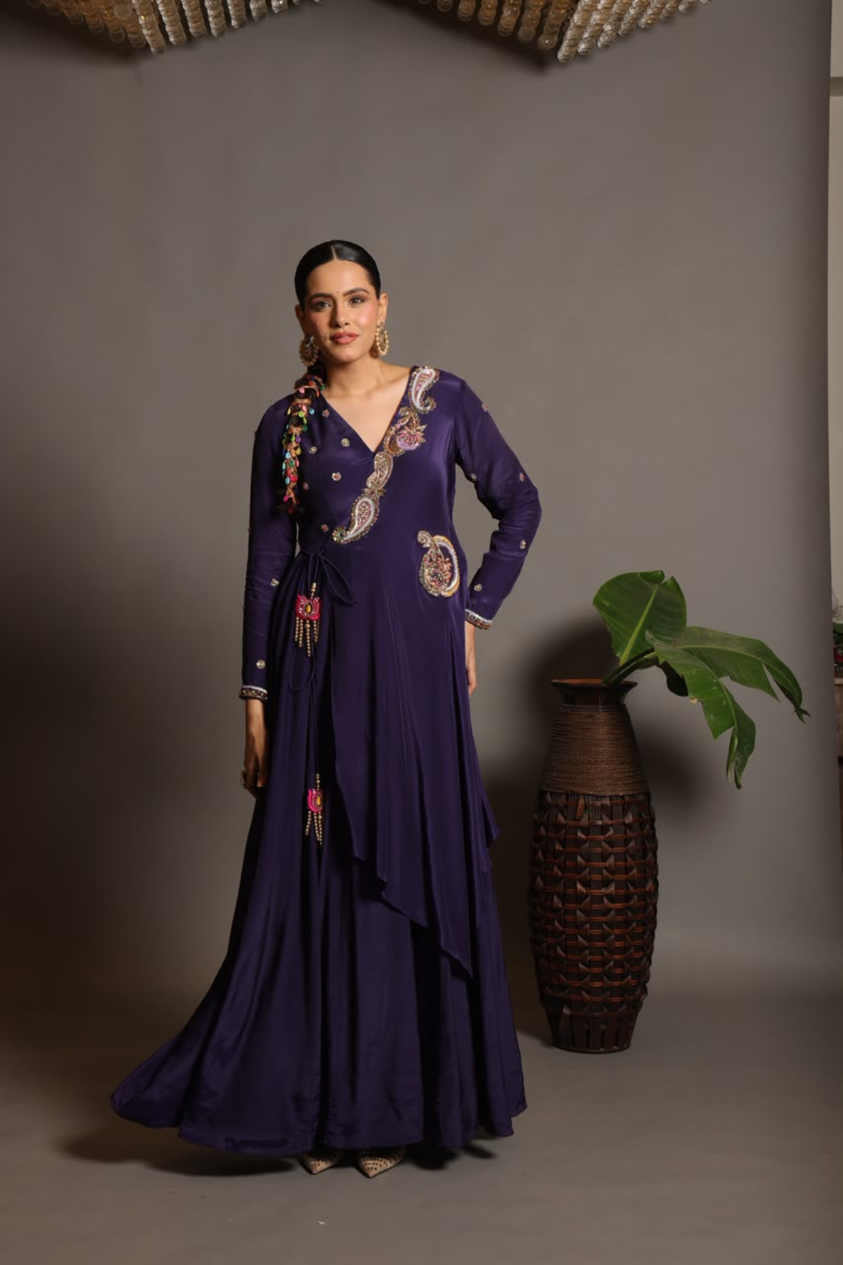 A sophisticated festive deep purple Anarkali crafted in luxurious fluid fabric with a graceful layered flare. Intricate multicolour floral and paisley embroidered adds a rich artisanal touch.handcrafted statement tassels ,a flattering tie-up waist & delicate embellishment.  Shop Now!