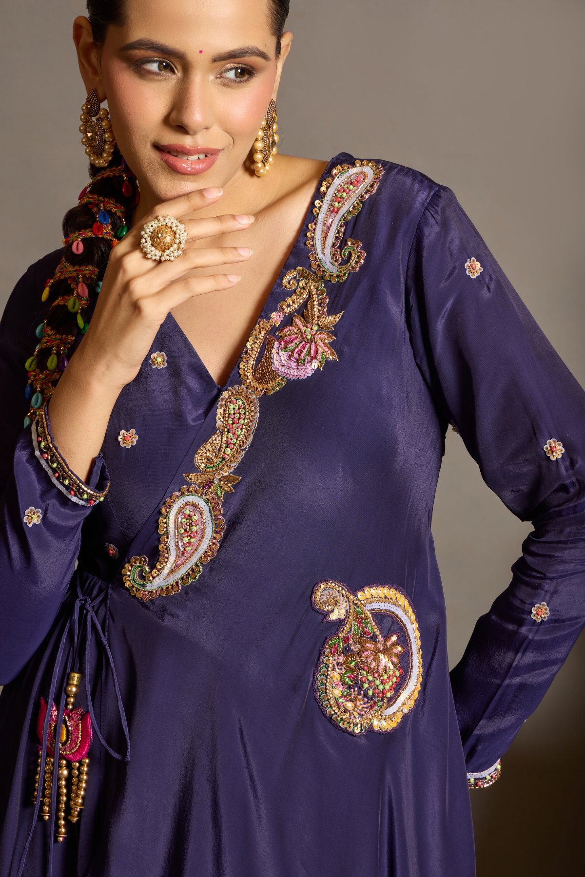 A sophisticated festive deep purple Anarkali crafted in luxurious fluid fabric with a graceful layered flare. Intricate multicolour floral and paisley embroidered adds a rich artisanal touch.handcrafted statement tassels ,a flattering tie-up waist & delicate embellishment.  Shop Now!