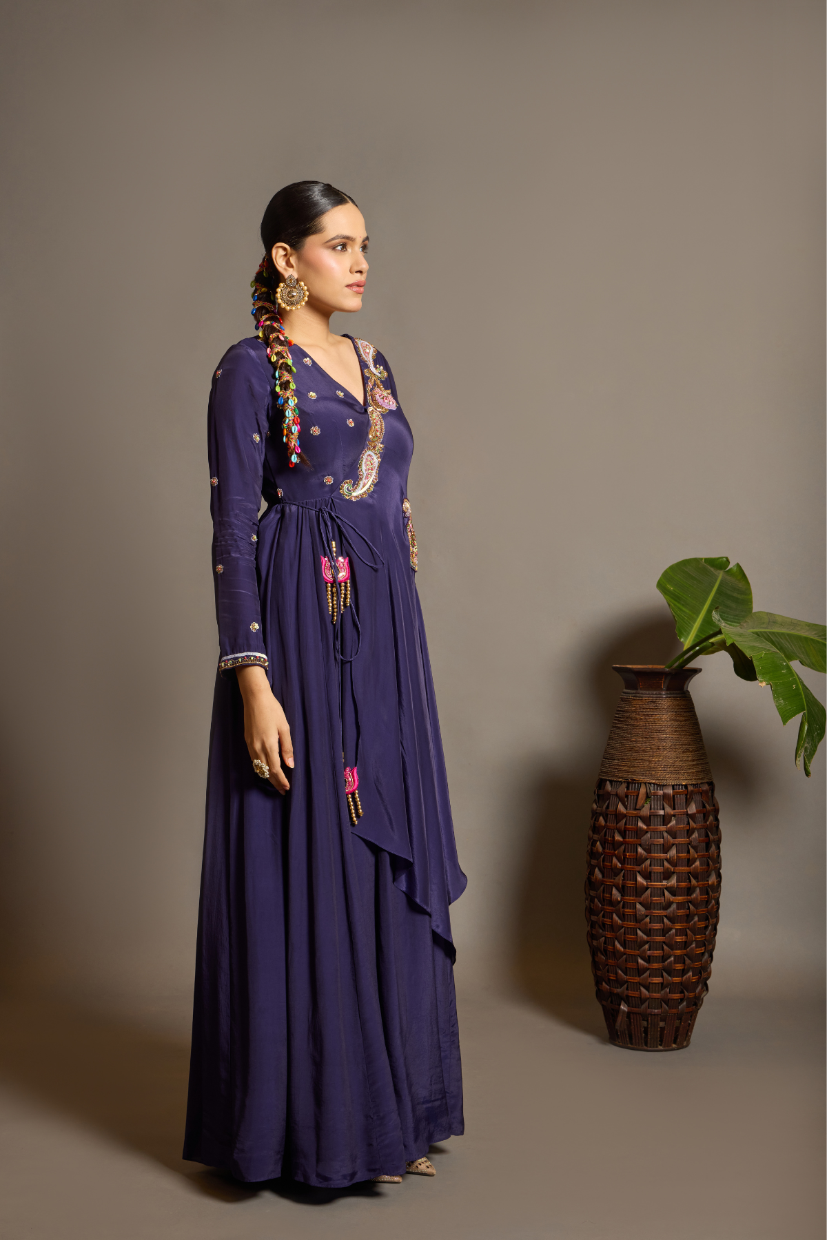 A sophisticated festive deep purple Anarkali crafted in luxurious fluid fabric with a graceful layered flare. Intricate multicolour floral and paisley embroidered adds a rich artisanal touch.handcrafted statement tassels ,a flattering tie-up waist & delicate embellishment.  Shop Now!