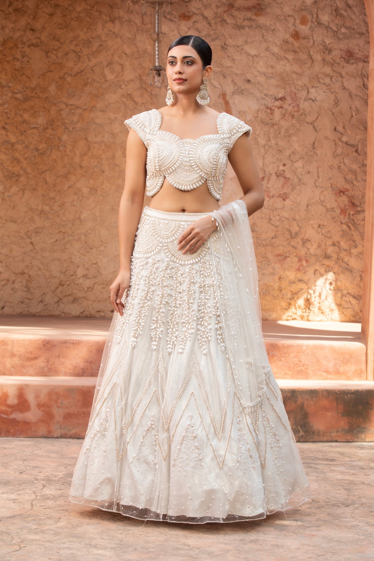 Ivory metallic foil net lehenga with pearl beadwork and scalloped detailing — perfect for bridesmaids. Shop Now!