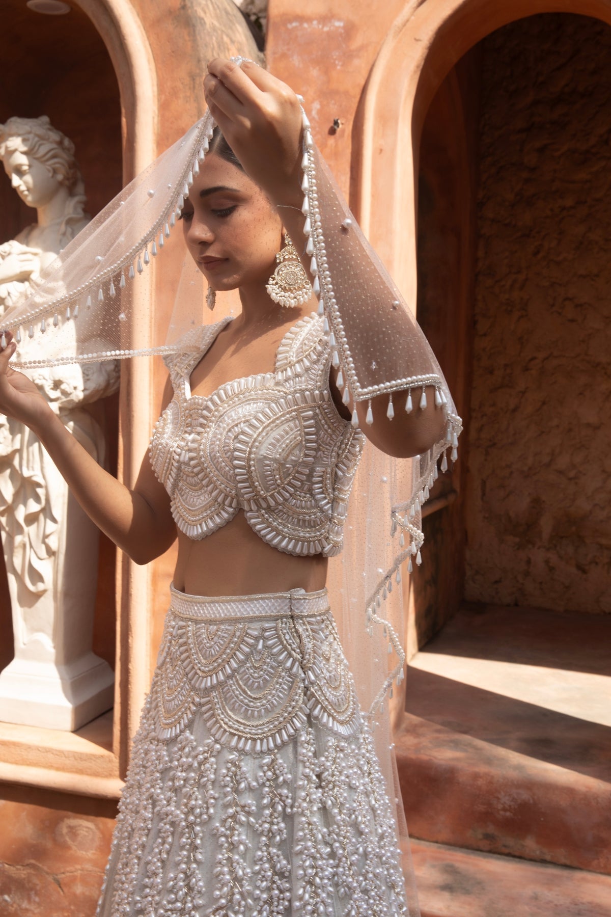 Ivory metallic foil net lehenga with pearl beadwork and scalloped detailing — perfect for bridesmaids. Shop Now!