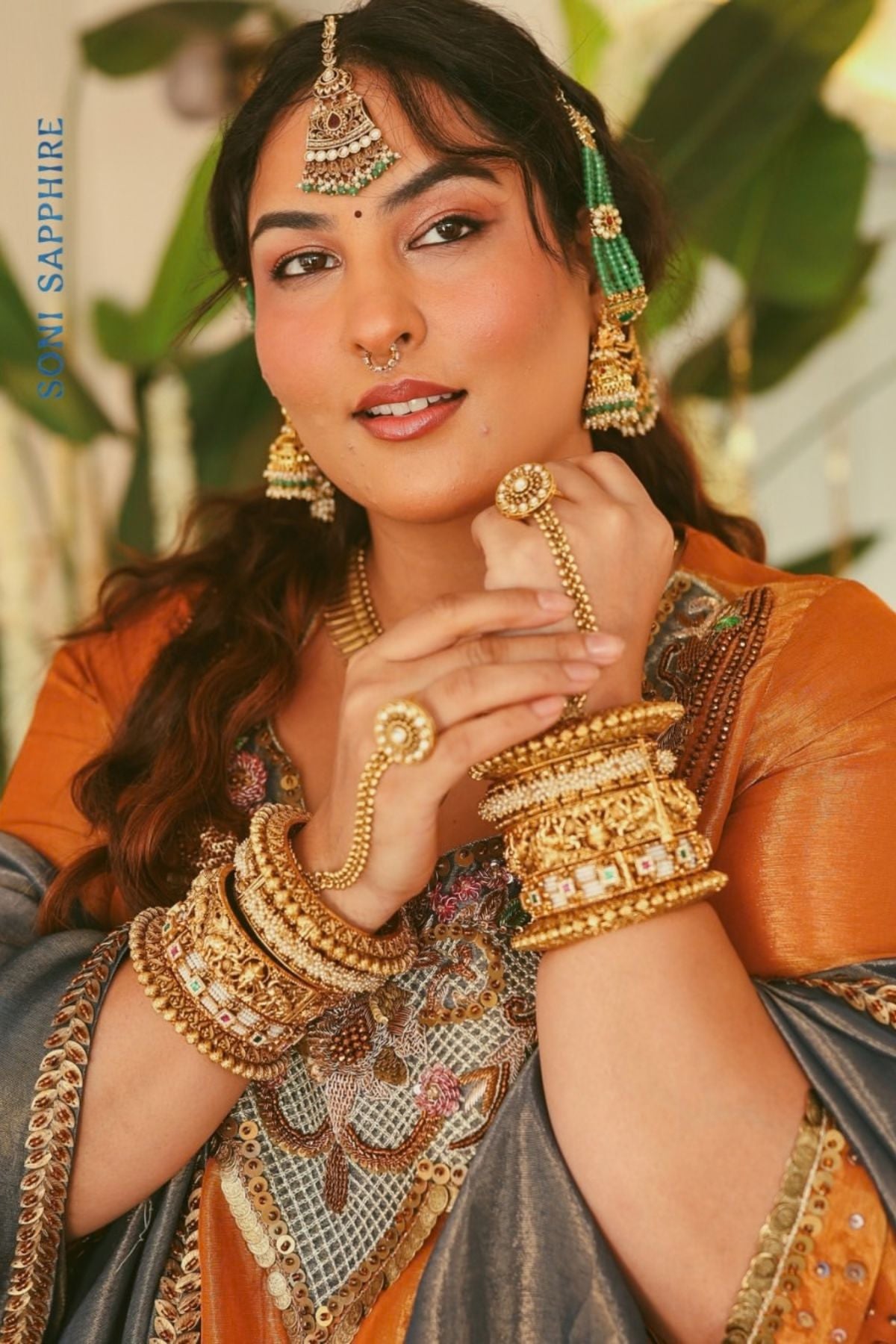 A luminous burnt-orange kurta in a rich metallic finish, elevated with an ornate handcrafted embroidered yoke. The statement neckline features intricate multicolour florals, paisleys,sequins and antique-gold detailing. Layered with a deep-navy blue metallic dupatta finished with ornate borders and delicate embellishment. A festive look that blends contemporary glamour with traditional Indian craftsmanship. Shop Now!