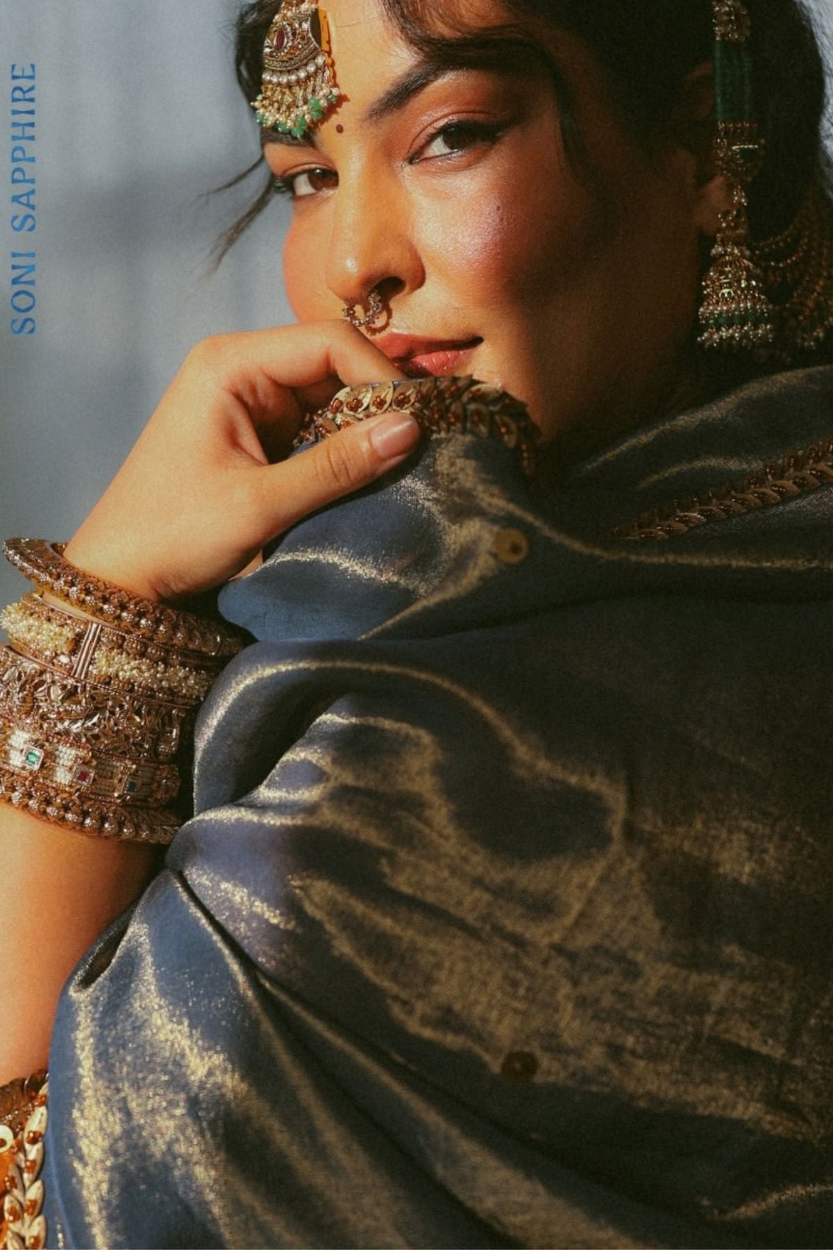 A luminous burnt-orange kurta in a rich metallic finish, elevated with an ornate handcrafted embroidered yoke. The statement neckline features intricate multicolour florals, paisleys,sequins and antique-gold detailing. Layered with a deep-navy blue metallic dupatta finished with ornate borders and delicate embellishment. A festive look that blends contemporary glamour with traditional Indian craftsmanship. Shop Now!