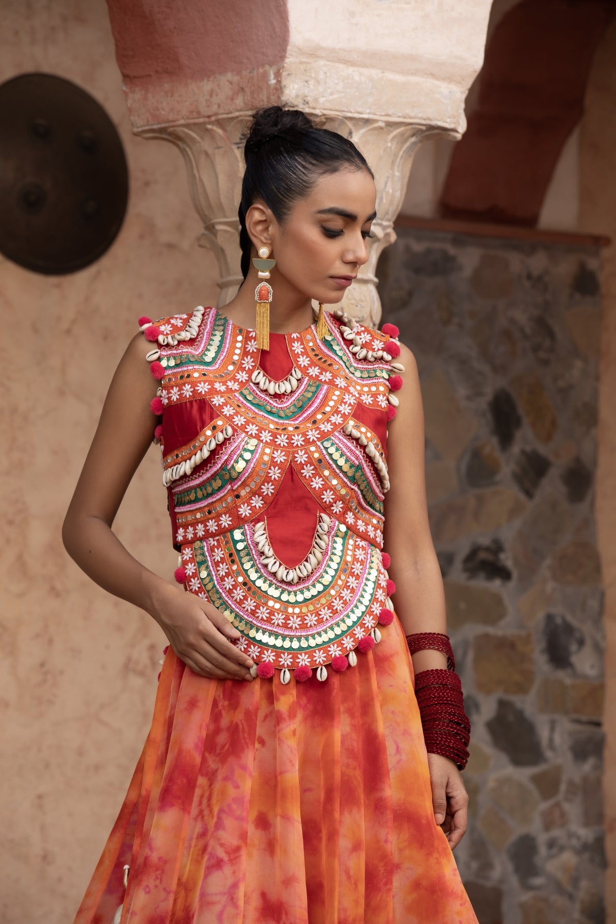 Tangerine tie-dye lehenga with coin-cadi and pearl work crop top, embellished in quirky Gujarati style with pom-pom and puppet tassels Shop Now!