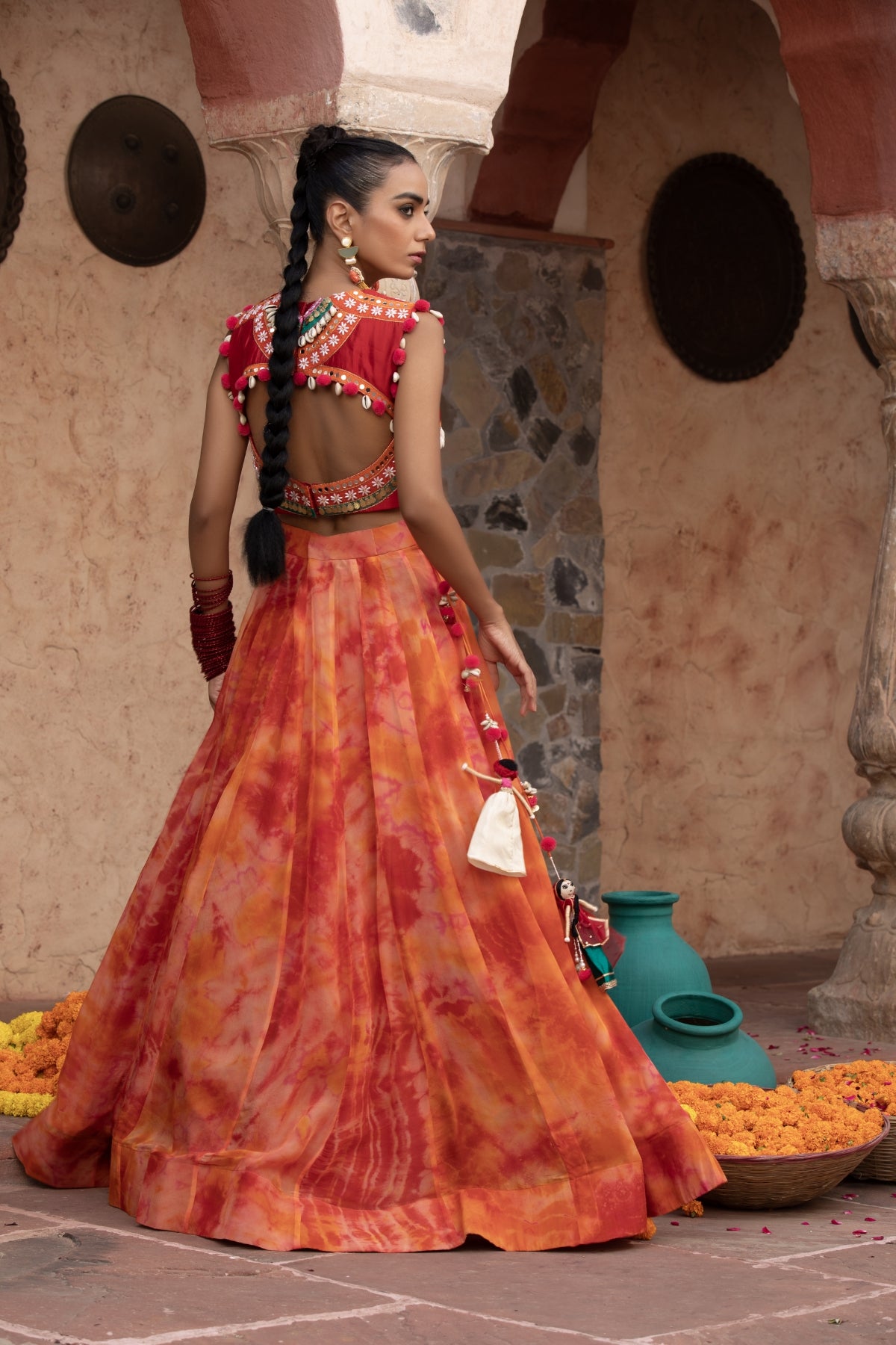 Tangerine tie-dye lehenga with coin-cadi and pearl work crop top, embellished in quirky Gujarati style with pom-pom and puppet tassels Shop Now!