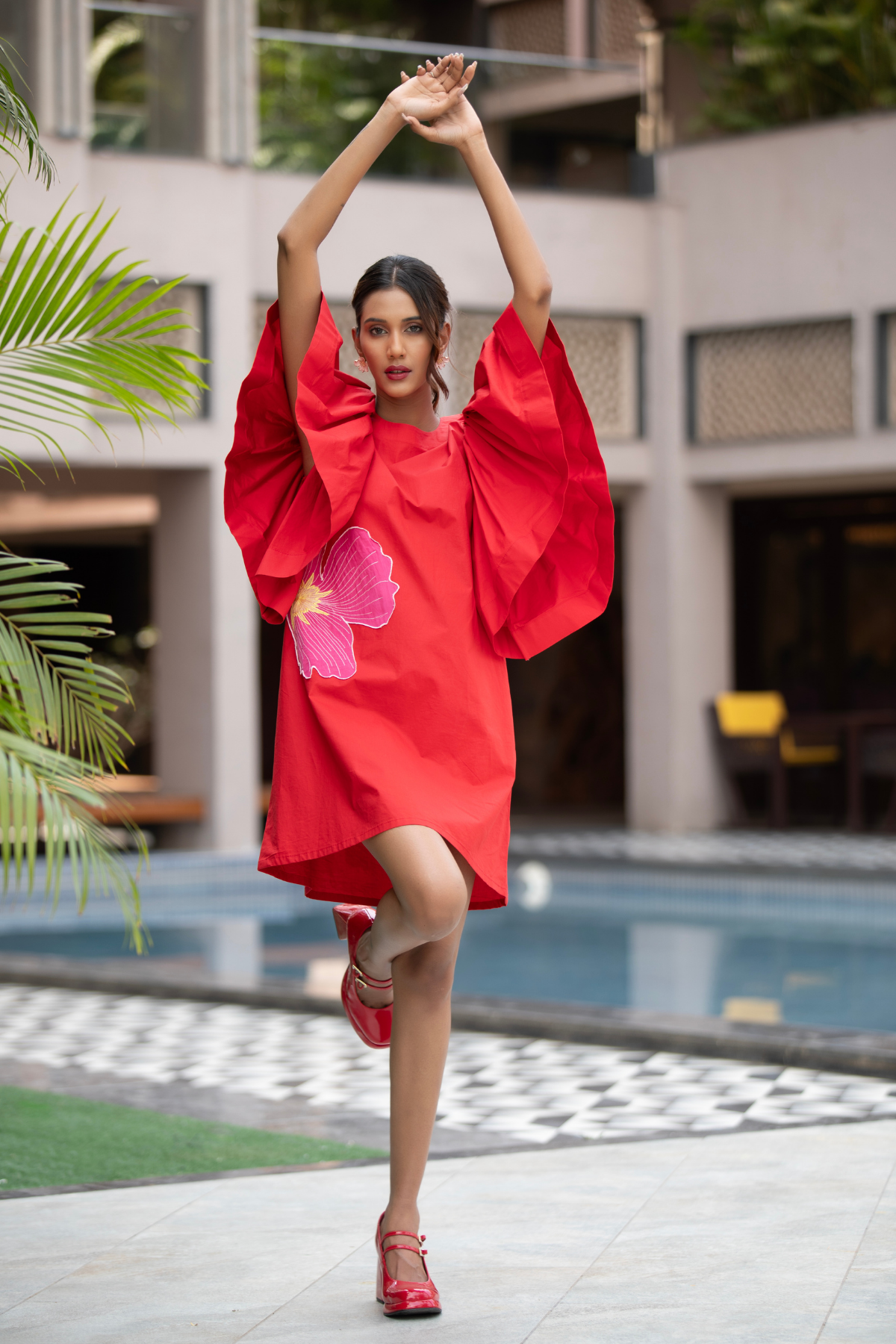 The dress is a vibrant red shift mini dress balance as relaxed fit and bold architectural details Shop Now!