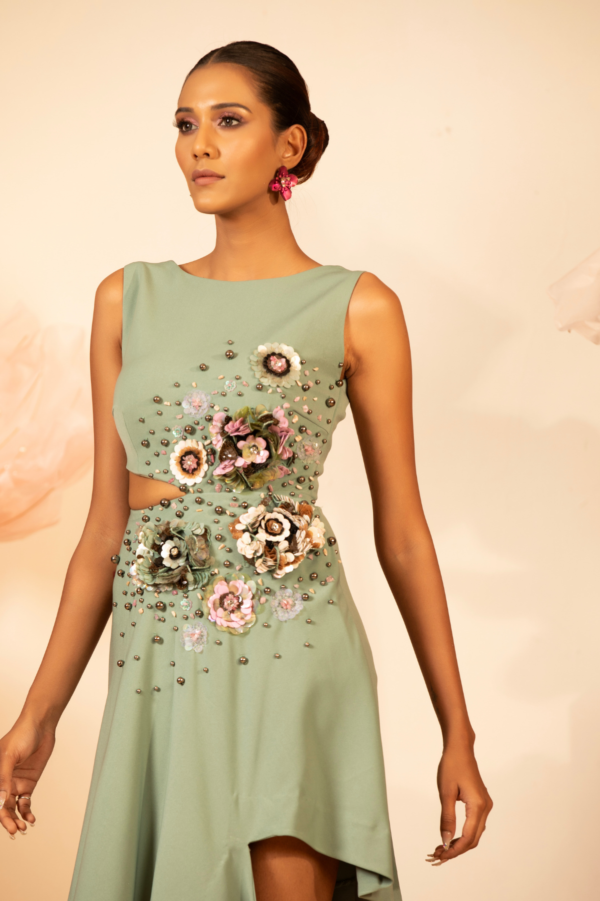 The dress is heavy dimentional embellishments sleeveless and high boat neckline, asymmetric side cutout with 3D floral hand embroidery Shop Now!
