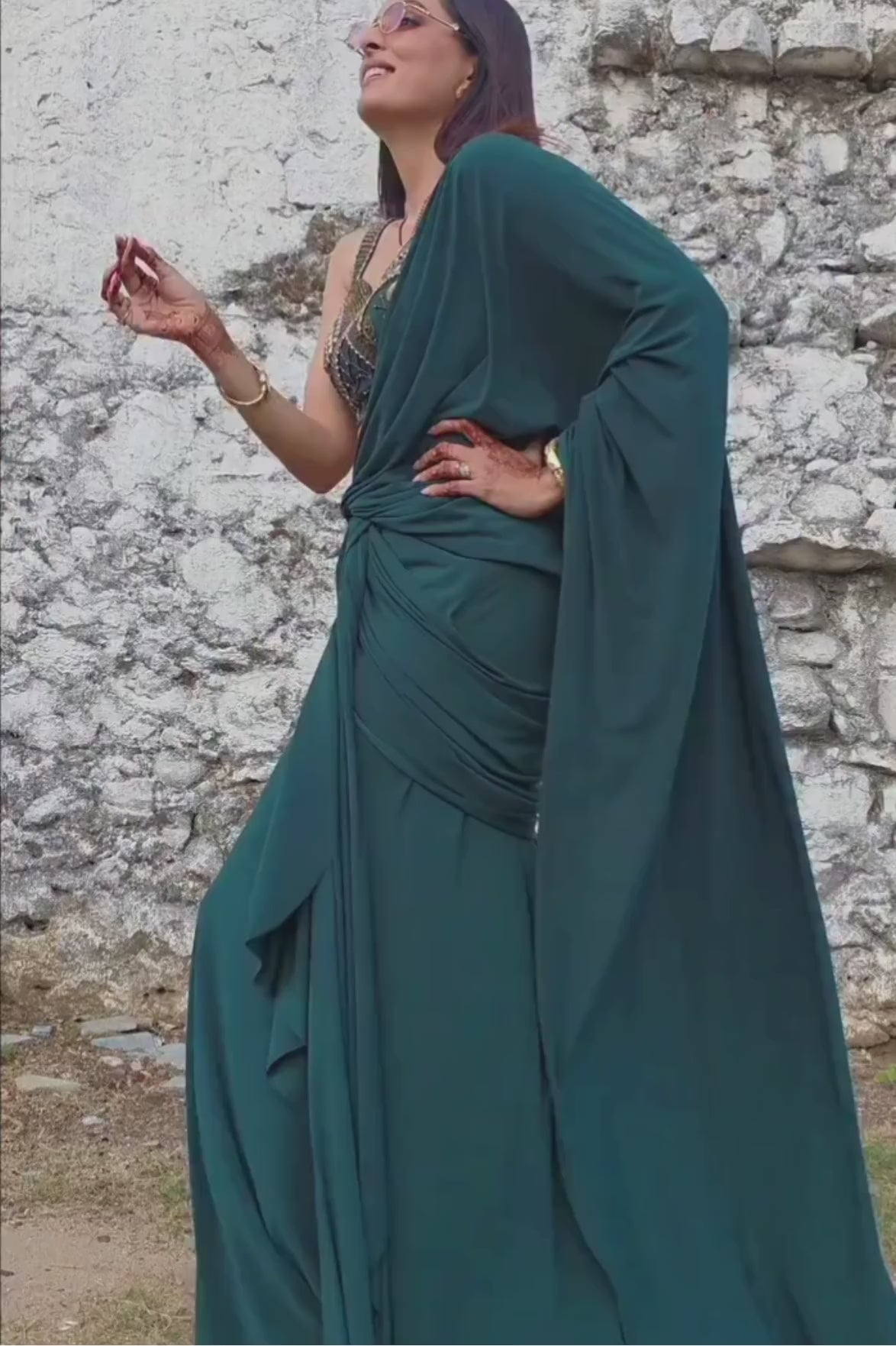 Emerald green pre-draped lycra saree with metallic rivet, sequin, bead, and cutdana work, paired with a corset blouse Shop Now!