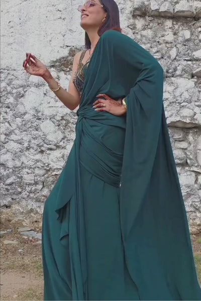 Emerald green pre-draped lycra saree with metallic rivet, sequin, bead, and cutdana work, paired with a corset blouse Shop Now!