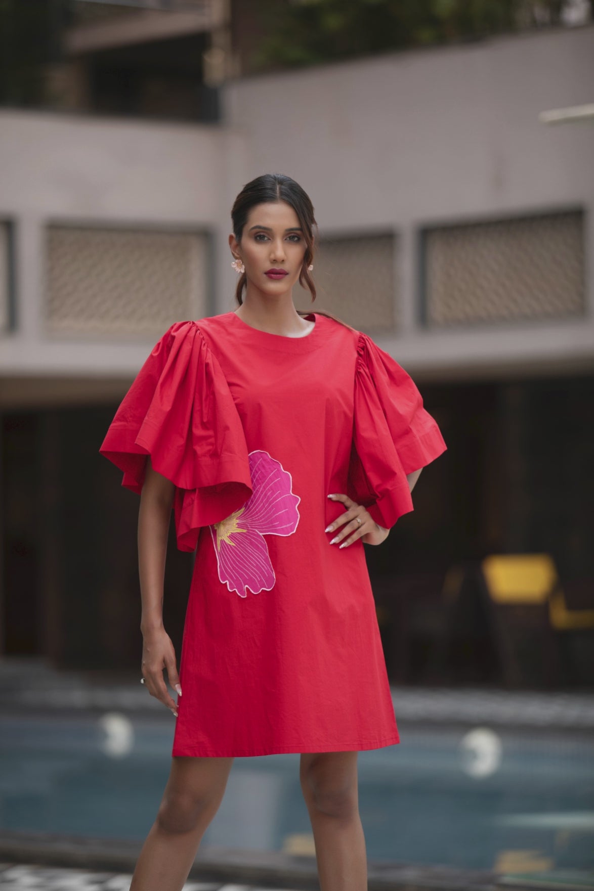 The dress is a vibrant red shift mini dress balance as relaxed fit and bold architectural details Shop Now!