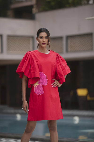 The dress is a vibrant red shift mini dress balance as relaxed fit and bold architectural details Shop Now!