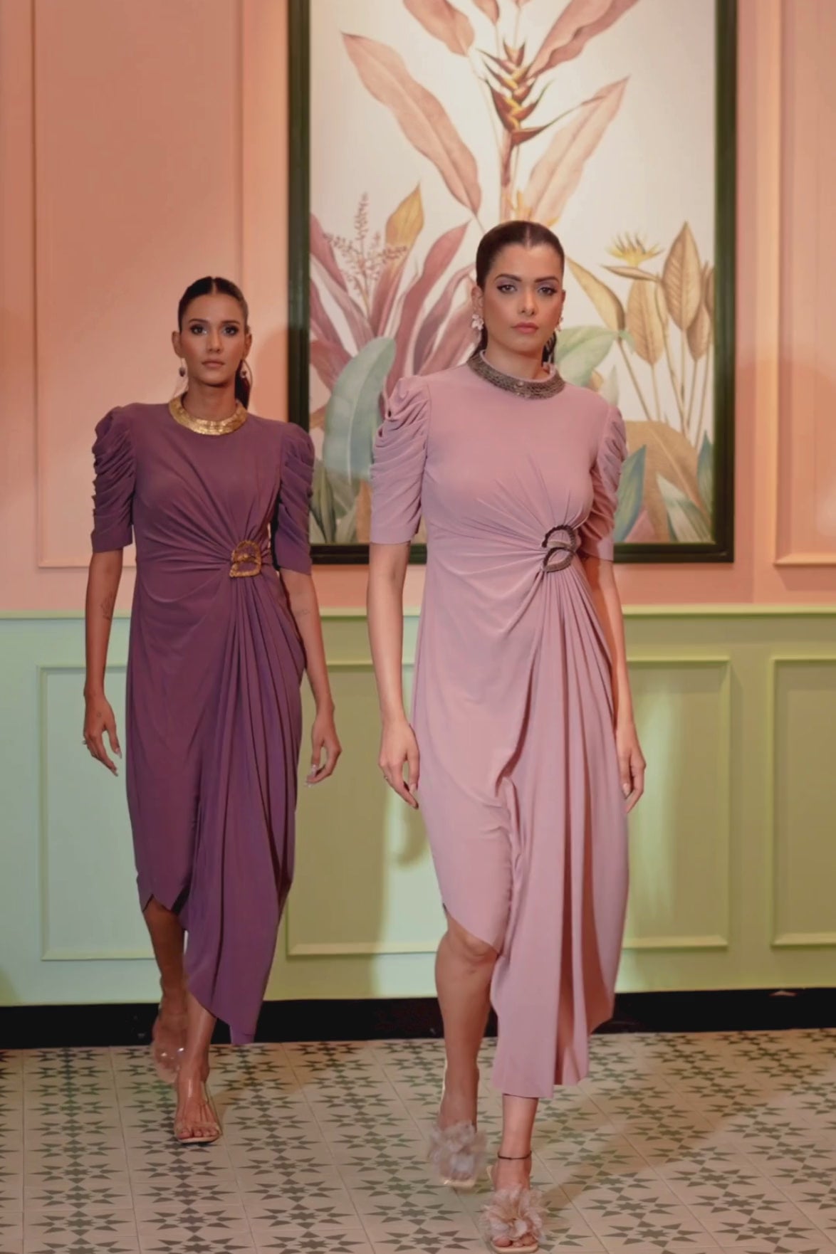 The blush coin drape dress fitted bodices with distinctive drape wrape style front that gather at the waist puff sleeve a classic high round neckline hand work elements like pearl beads Shop Now!