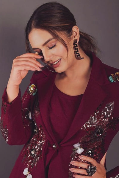Tailored to sartorial perfection this single-breasted roll collar, peplum style blazer is paired with classic trousers. Its artistic intricate hand-embroidery with a mix of pipes, beads, sequin,cutdana, etc reflects aesthetic craftsmanship . Shop Now!